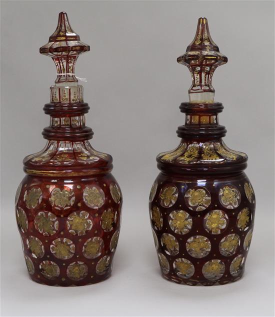 A pair of Bohemian gilt and ruby flash cut decanters with spear stoppers height 34cm